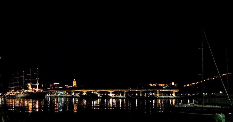 Puerto de Málaga con marina, palmeras y edificios de la ciudad junto al mar