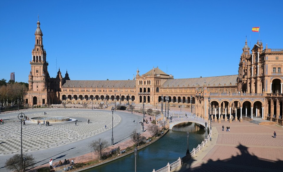 Plaza de España de Sevilla con arquitectura semicircular y canal bajo el cielo azul